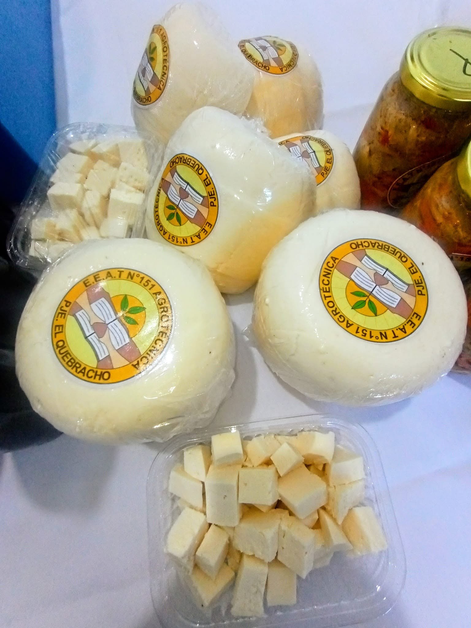 Quesos y cuadraditos de queso elaborados por la escuela, con la etiqueta E.E.A.T. N°151